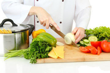 Female hands cutting vegetables, isolated on white