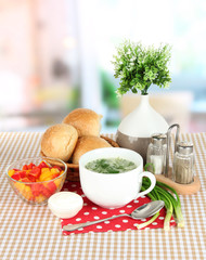 Fragrant soup in cup on table in kitchen