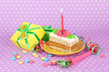Colorful birthday cake with candle and gifts on pink background