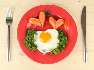 Sausages in form of hearts, scrambled eggs and parsley,