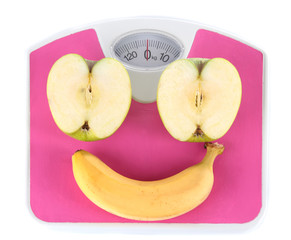 Apple and banana on scales isolated on white