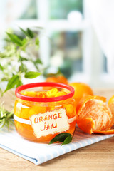 Orange jam with zest and tangerines, on wooden table