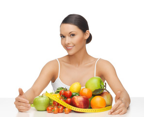 woman with measuring tape and lots of fruits