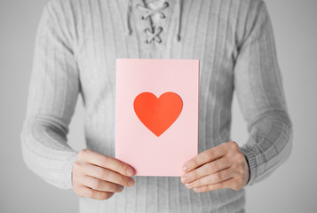 man holding postcard with heart shape