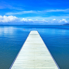 Wooden pier or jetty on a blue ocean. Beach in Argentario, Italy