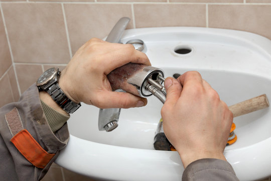 Plumber work, fixing water tap in a bathroom