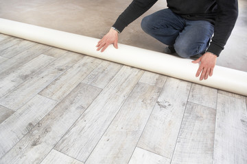 rolling out a PVC flooring - obrazy, fototapety, plakaty