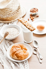 healthy breakfast: croissant, porridge, almonds and milk