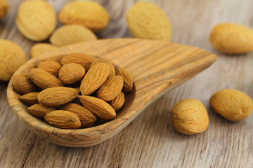 Almonds with and without shell on wooden background
