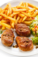 Grilled steaks, French fries and vegetables