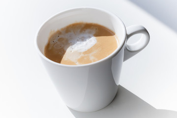 Cappuccino coffee in a ceramic cup on white table