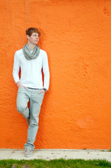 Young man standing by the wall