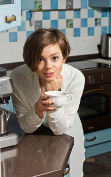 Young Woman on Kitchen Counter Holding Tea Cup