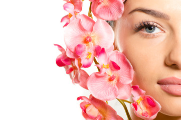 Closeup on beautiful girl face & pink flowers, perfect skin