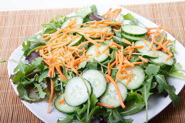 White Plate of Fresh Salad on Bamboo Mat