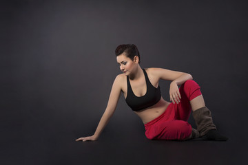 Obraz premium junge sportliche frau sitzend in sportbekleidung