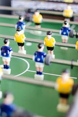 Table football game with yellow and blue players