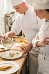 Male baker showing apprentice serving puff pastry