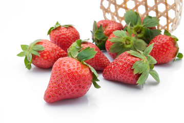 strawberries in woven basket on white