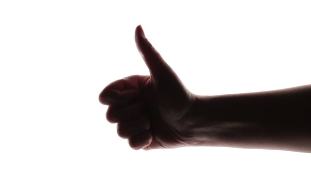 Silhouette of woman's hand giving thumb up on white background.
