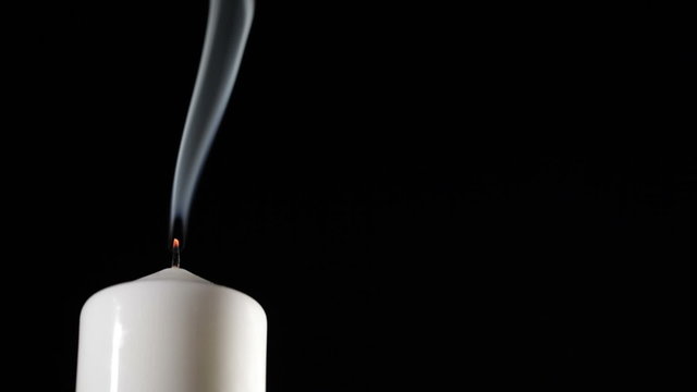 Extinguished candle with beautiful dancing smoke.