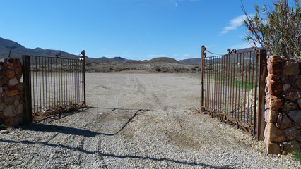 Portail rouillé ouvert sur terrain non construit
