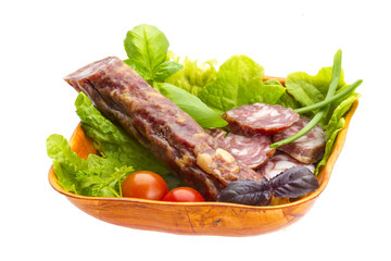 Ripe salami with salad, basil, onion and tomato