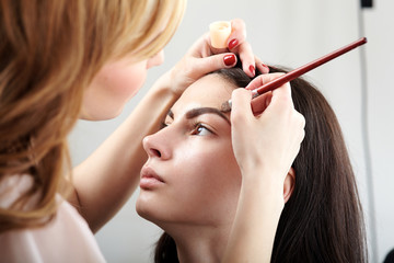Woman having makeup applied by makeup artist