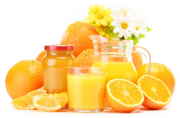 Glass and jug of orange juice, jar of jam and fruits
