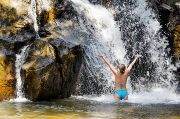 Young woman relaxing in waterfall