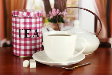 Jar and cup of tea on table in room