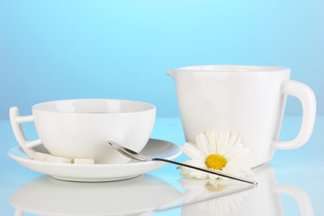 A cup of strong coffee and sweet cream on blue background
