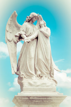 Statue of an angel guarding a beautiful young girl