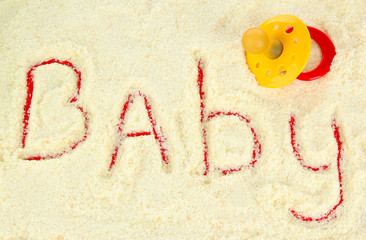 Word baby making with powdered milk on red background