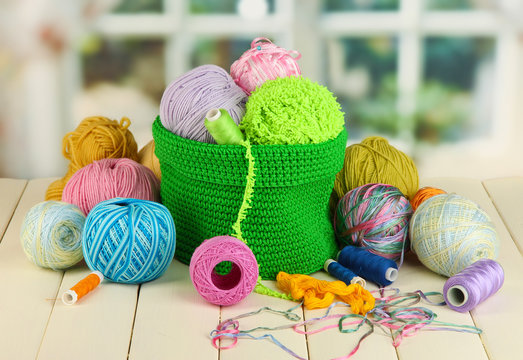 Colorful yarn for knitting in green basket