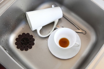 Dishwashing. White dishes in the kitchen sink.