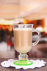 Layered coffee in glass on table on bright background