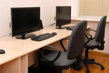 Computers on tables in room