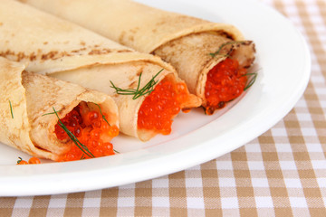 Delicious pancakes with red caviar on table close-up