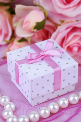 Rose and gift box on pink cloth