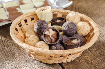 chocolates and chocolate in a basket on a wooden table