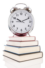 Alarm clock and books isolated on white