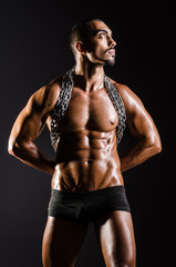 Fototapeta na wymiar Muscular man with chain on black background