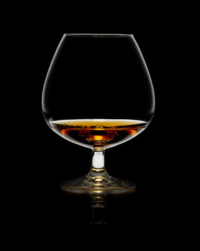Glass of whiskey over black background