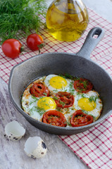 Breakfast with fried quail eggs with cherry tomatoes