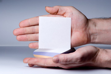 Men's hand points to a blank sheet of paper for notes