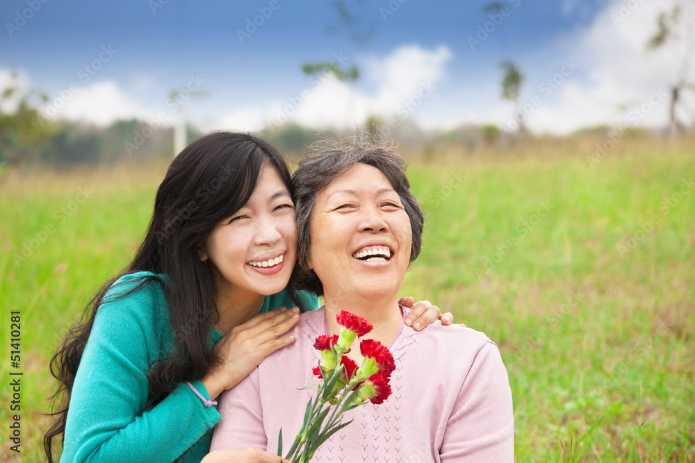 Sticker smiling daughter and her mother with carnation flower on the gra