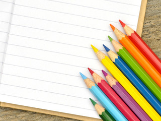 Buntstifte auf liniertem Notizbuch
