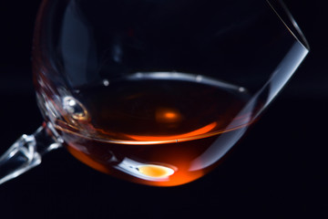 snifter with brandy on a dark background.