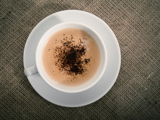 Black coffee over old burlap background